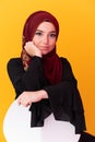 beautiful muslim woman in fashinable dress with hijab isolated on modern yellow background representing concept of Royalty Free Stock Photo