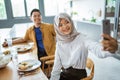 muslim woman taking selfie with her partner while having lunch together Royalty Free Stock Photo