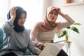 Beautiful muslim woman upset business woman trying to concentrate looking at laptop monitor