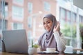 Beautiful Muslim woman using computer to greet attendees via video conference
