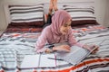 beautiful muslim woman working on laptop while lying down on bed Royalty Free Stock Photo