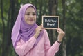 Beautiful muslimah stand and holding chalkboard with word BUILD YOUR BRAND.