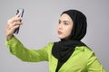 Beautiful musllim woman with hijab using smartphone over white background, technology concept