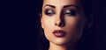 Beautiful mysterious smokey eyes makeup woman in darkness looking dramatic with healthy tan yellow skin tone on black background