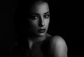 Beautiful mysterious woman in darkness looking dramatic on black background with empty copy space. Closeup portrait Royalty Free Stock Photo