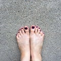 Beautiful Nail, Close Up Woman`s Bare Feet and Red Nail Polish on Cement Floor Background
