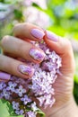 Beautiful nails with lilac flowers and fresh flowers Royalty Free Stock Photo