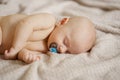 a beautiful naked baby with nipple sleeps on the bed. Royalty Free Stock Photo