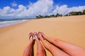 The beautiful naked legs of a couple wearing flip flops on the sandy beach Praia Do Mutari Brava, Porto Seguro, Brazil Royalty Free Stock Photo