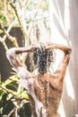 Beautiful naked young woman taking shower in bathroom outside on he luxury villa. Tropical Bali island, Indonesia. Royalty Free Stock Photo