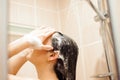 Beautiful naked young woman using shampoo while taking shower Royalty Free Stock Photo