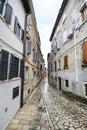 Beautiful narrow street with ancient building facades and paving stones in the coastal town of Rovinj, Croatia Royalty Free Stock Photo