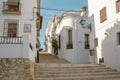 Beautiful narrow street with cobblestone stairs in an old town with white houses and tiled roofs. Altea, Spain Royalty Free Stock Photo