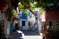 Beautiful narrow street in old town of Marmaris with plants and flowers on sunny day, Turkey. Blue balcony and door on Royalty Free Stock Photo