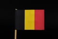 A beautiful, national flag of the kingdom of Belgium on toothpick on black background. A vertical tricolour of black, yellow, and Royalty Free Stock Photo