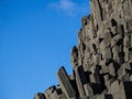 Beautiful natural basalt rock formation near Vik in Iceland rising up into clear blue sky