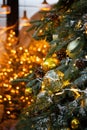 Beautiful natural Christmas tree with Golden balls and garlands. The defocus of the Golden lights from the garland. Royalty Free Stock Photo