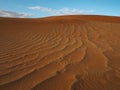 Beautiful natural pattern of rusty red sand dune with blue sky and white cloud background, Sossus, Namib Dessert Royalty Free Stock Photo