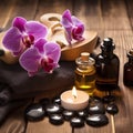 Beautiful natural pink orchid flowers, black massage stones and bottles of aromatic oil on the dark background of the spa salon Royalty Free Stock Photo