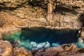 Beautiful natural pool of crystal clear water formed in a rocky cave with stalagmites and stalagmites