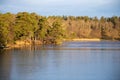 Beautiful natural Scandinavian landscape. Frozen lake with forest and stones at the shore line. Royalty Free Stock Photo