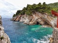 Beautiful natural view of a rocky cliff covered with trees at the sea in Ohrid Royalty Free Stock Photo