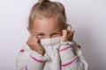 Beautiful natural young shy girl with smiling eyes wearing knitted sweater