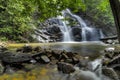 Amazing cascading tropical waterfall. wet and mossy rock, surrounded by green rain forest Royalty Free Stock Photo