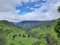 Beautiful landscape image of mountains half covered by clouds with the background of blue sky Royalty Free Stock Photo