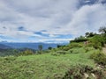 Beautiful landscape image of mountains half covered by clouds with the background of blue sky