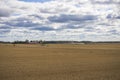 Beautiful nature landscape view of field after harvesting under cloudy summer sky.