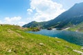 lake balea in the valley. hills covered in grass, rocks and snow. wonderful summer sunny Royalty Free Stock Photo