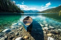 Beautiful nature scenery with a canoe boat on a crystal clear lake with pebbles mountains green trees and blue sky Royalty Free Stock Photo