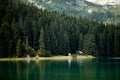 Beautiful nature scenery. Reflection in water of forest of towering pine trees. Emerald color lake and forest. Mountain lodge in Royalty Free Stock Photo