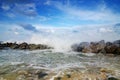 Beautiful nature, splashing wave while hitting the rock at the beach. cloudy blue sky Royalty Free Stock Photo