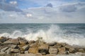 Beautiful nature, splashing wave while hitting the rock at the beach. cloudy blue sky Royalty Free Stock Photo