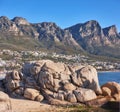 Beautiful, nature view of the beach front or rocky boulder on the seashore against a mountain landscape and blue sky on Royalty Free Stock Photo