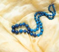 Beautiful necklace of dark blue faceted agate on yellow silk Royalty Free Stock Photo