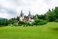 Beautiful neo-Renaissance building of Peles Castle Castelul Peles near Bucegi Mountains Muntii Bucegi in a cloudy summer day Royalty Free Stock Photo