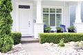 Beautiful new contemporary white home in a Canadian neighbourhood. Front door with a pretty porch and rock garden Royalty Free Stock Photo