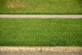 A beautiful new walkway made of paving stone is located among the green gras