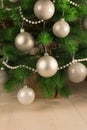 Beautiful New Year`s light background. Part of the Christmas tree decorated with silver balls and white beads. Festive