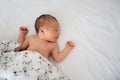 Beautiful newborn baby boy in bed. Infant lying down in bed Royalty Free Stock Photo