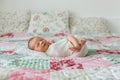 Beautiful newborn baby boy, widely smiling, wrapped in wrap, lying down in bed Royalty Free Stock Photo