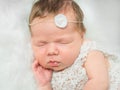 Beautiful newborn girl sleeping on fluffy plaid with toy