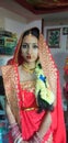 A beautiful newly married girl is sitting in sari and ornamants.
