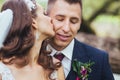 Beautiful newlywed bride and groom hugging in park.