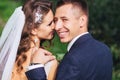 Beautiful newlywed bride and groom in park face closeup