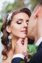 Beautiful newlywed bride and groom in park face close-up