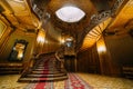 Beautiful newlywed bride and groom posing on old stairs with the background of breathtaking royal wooden vintage mansion